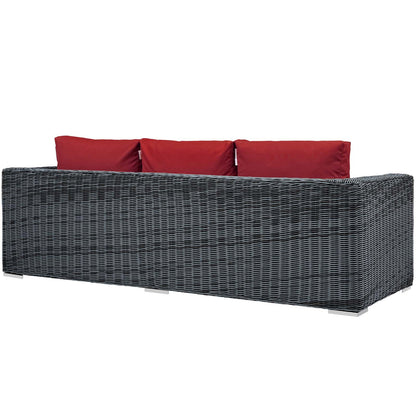 Grey wicker outdoor sofa with red cushions, modern patio seating, rectangular low-profile frame.