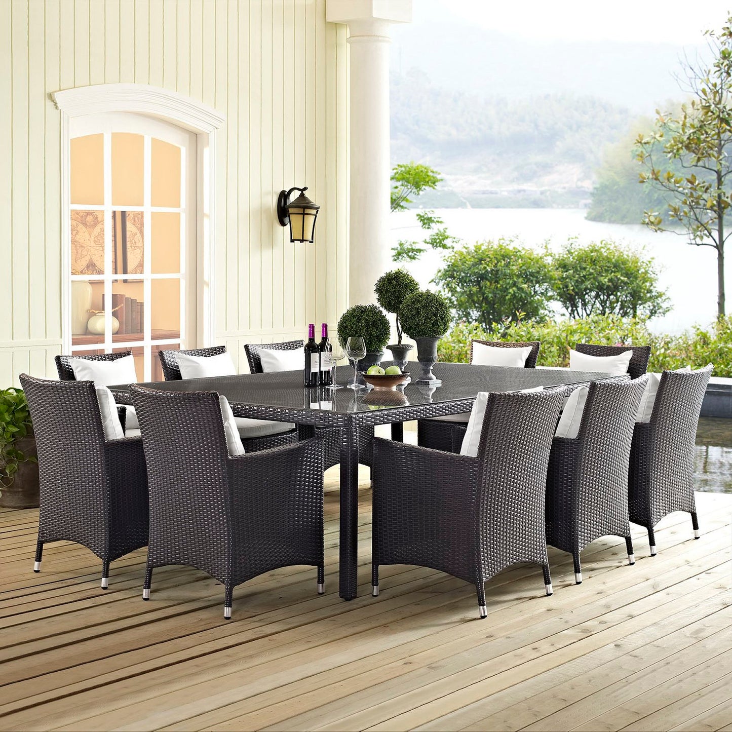 Rectangular espresso outdoor dining table on a wooden deck, lakeside view.