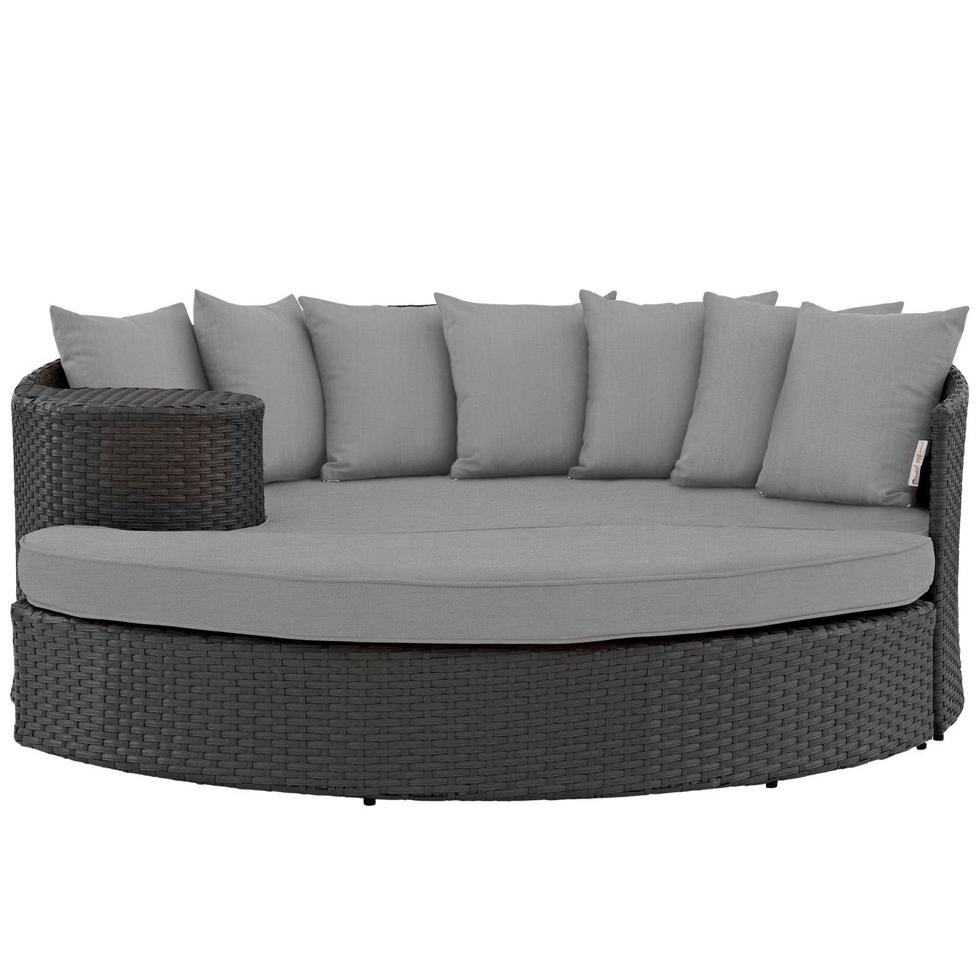 Round dark wicker outdoor daybed with light gray cushions and back pillows in a curved sectional style.