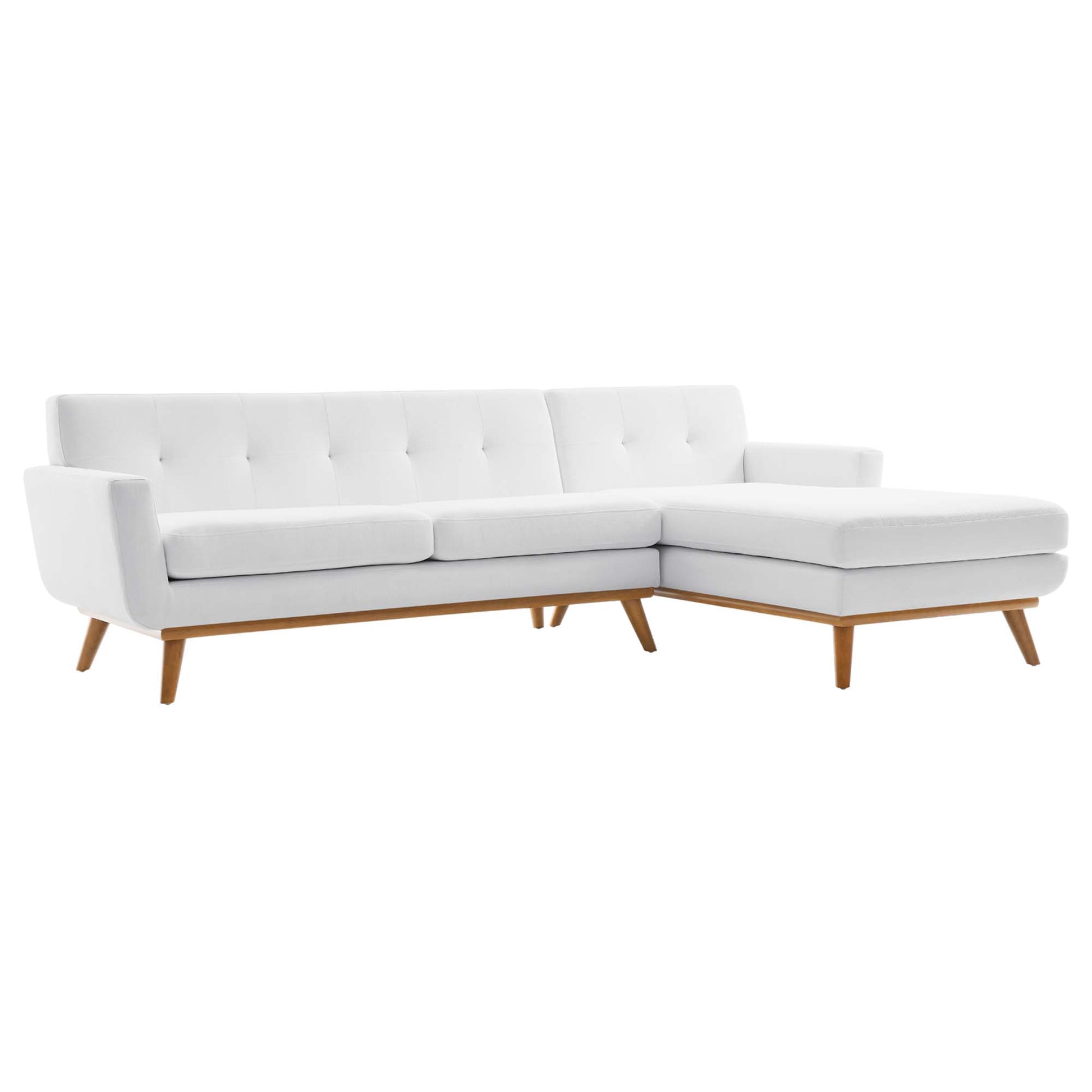 White fabric sectional sofa with tufted back, chaise lounge on the right, mid-century wooden legs.