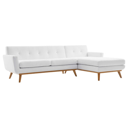White fabric sectional sofa with tufted back, chaise lounge on the right, mid-century wooden legs.
