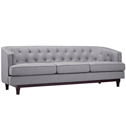 Gray fabric tufted sofa with curved back, three seat cushions & dark wooden legs.
