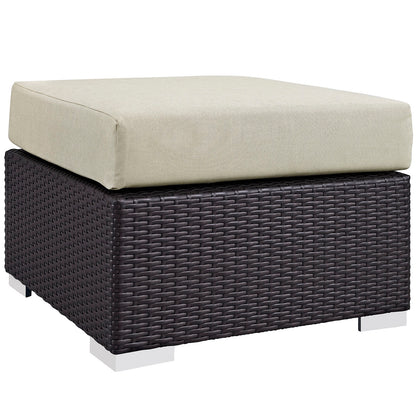Dark brown woven resin wicker ottoman with beige cushioned top, outdoor seating.