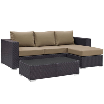Dark brown wicker outdoor sectional with tan cushions, left arm sofa plus chaise, and matching rectangular coffee table.