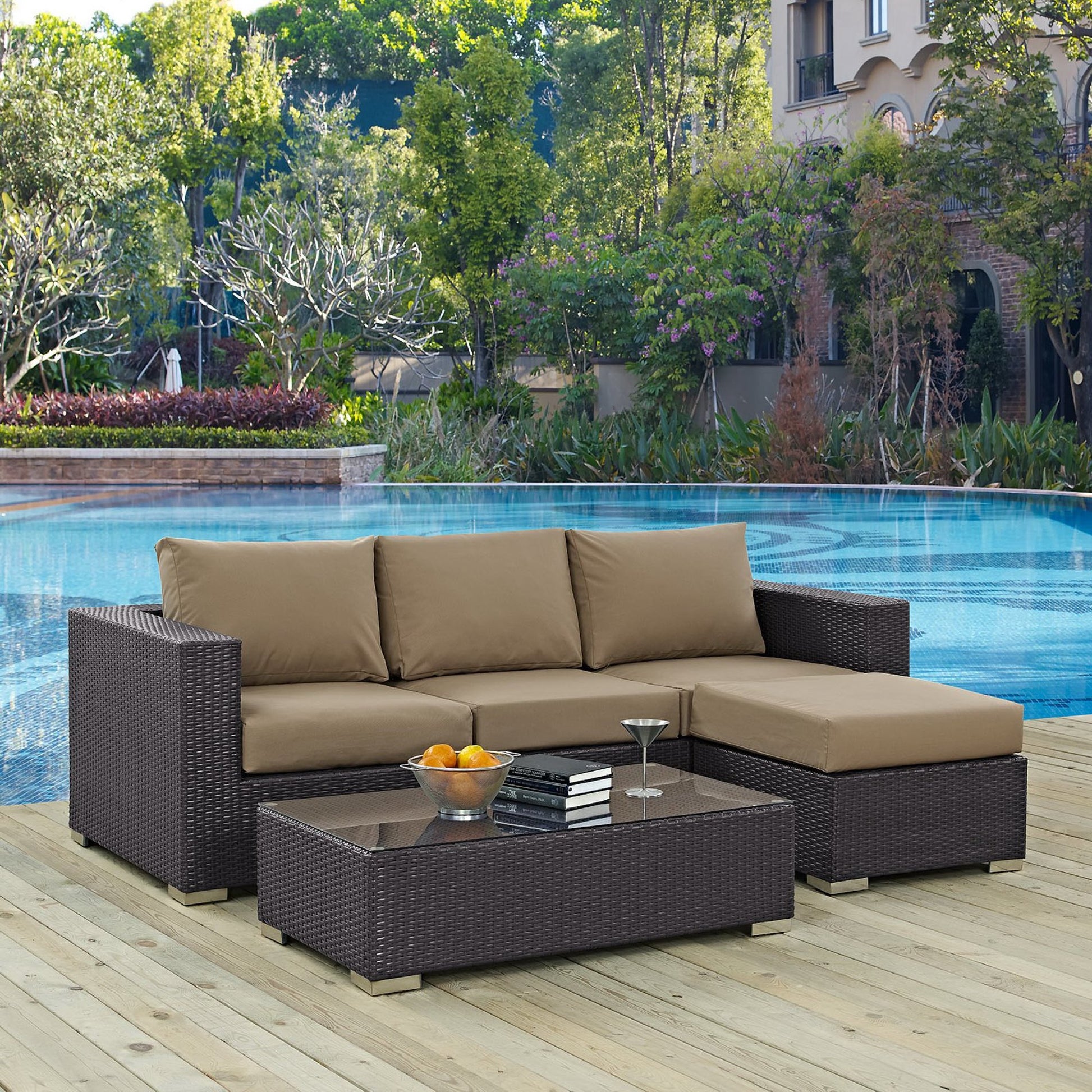 Dark espresso-mocha wicker outdoor 3-piece patio sofa set with beige cushions and glass-top coffee table on a wooden pool deck