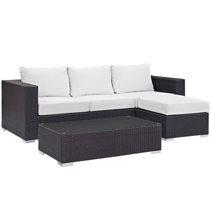 Dark brown wicker outdoor sectional with white cushions and a glass-topped coffee table.