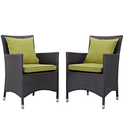 Pair of dark brown wicker outdoor patio dining chairs with lime green seat cushions and back pillows.