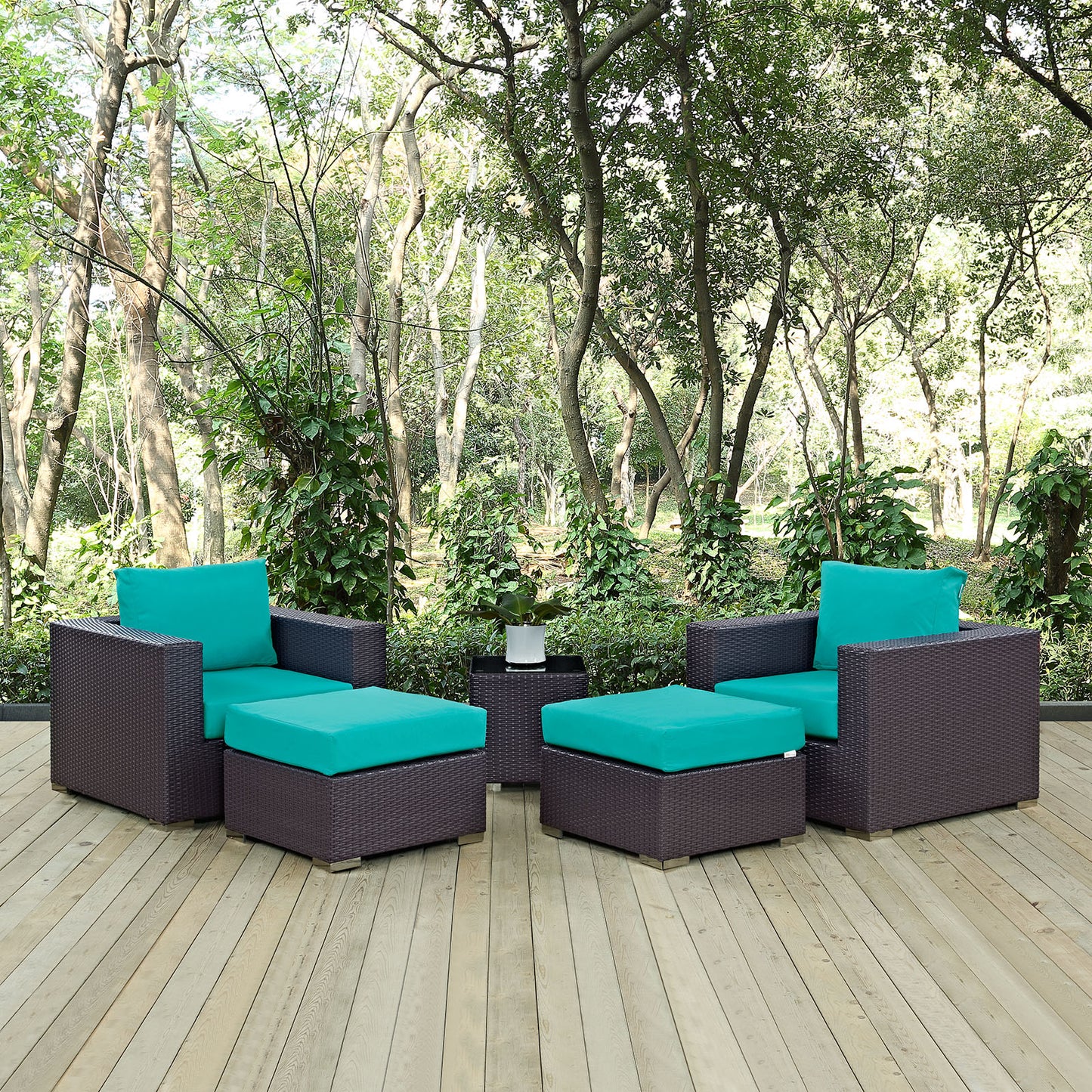 Dark brown wicker outdoor seating set with teal cushions; two armchairs, two ottomans, and a small side table.