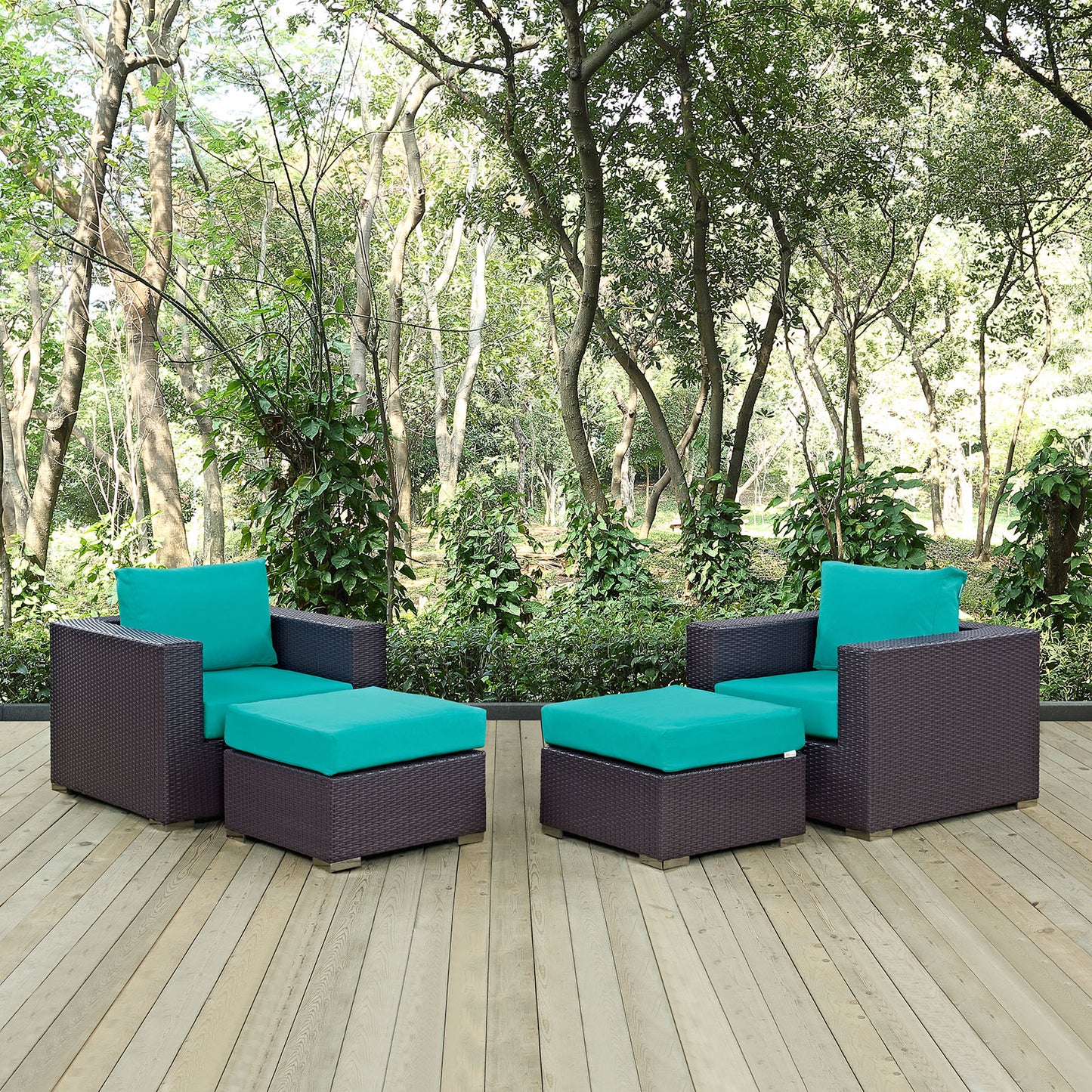 4-piece outdoor sectional set with turquoise cushions on a wooden deck, wicker seating with two armchairs & two ottomans, garden backdrop.