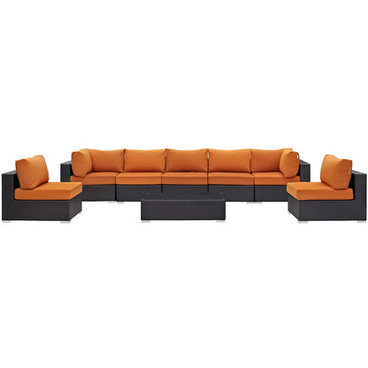 Modular espresso wicker outdoor sectional with orange cushions, includes coffee table and matching ottomans.