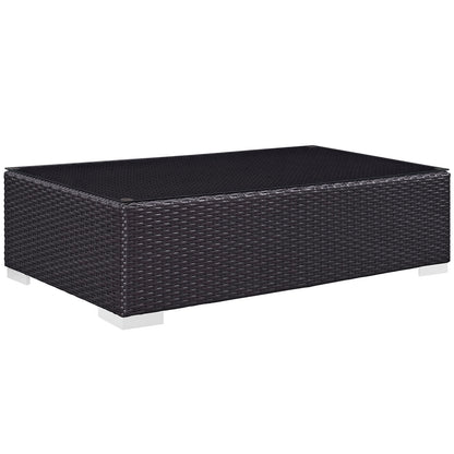 Dark brown synthetic rattan outdoor 8-piece sectional set with a rectangular glass-top coffee table, low-profile patio furniture.