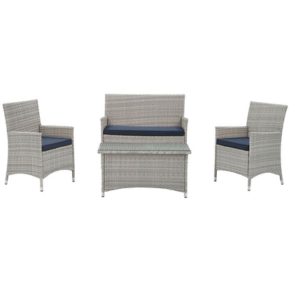 Gray wicker outdoor conversation set with navy cushions: two armchairs, a loveseat, and a matching coffee table.