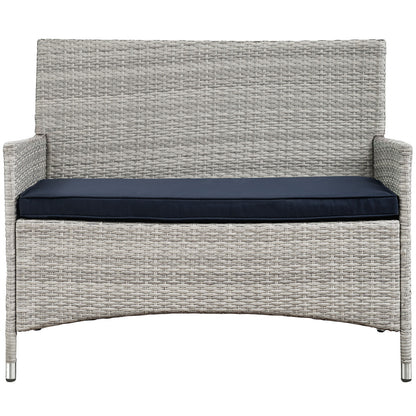 Light gray wicker 4-piece outdoor patio conversation set with navy cushions, curved bases, and slim armrests.