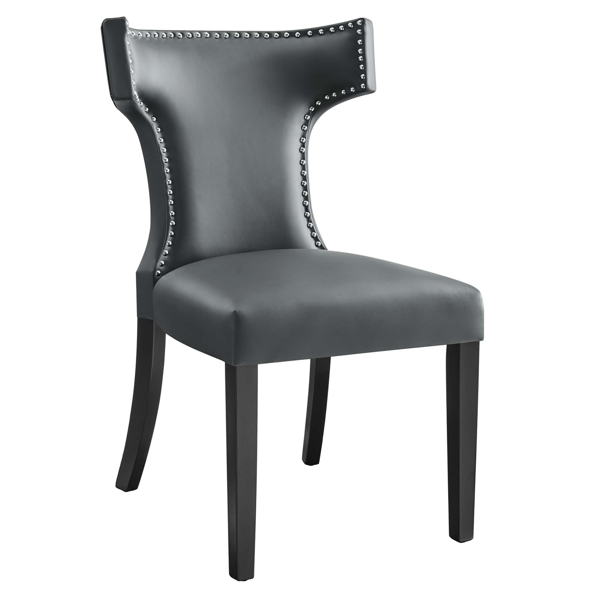 Gray faux leather dining chair with silver nailhead trim, curved wingback and dark wood legs.