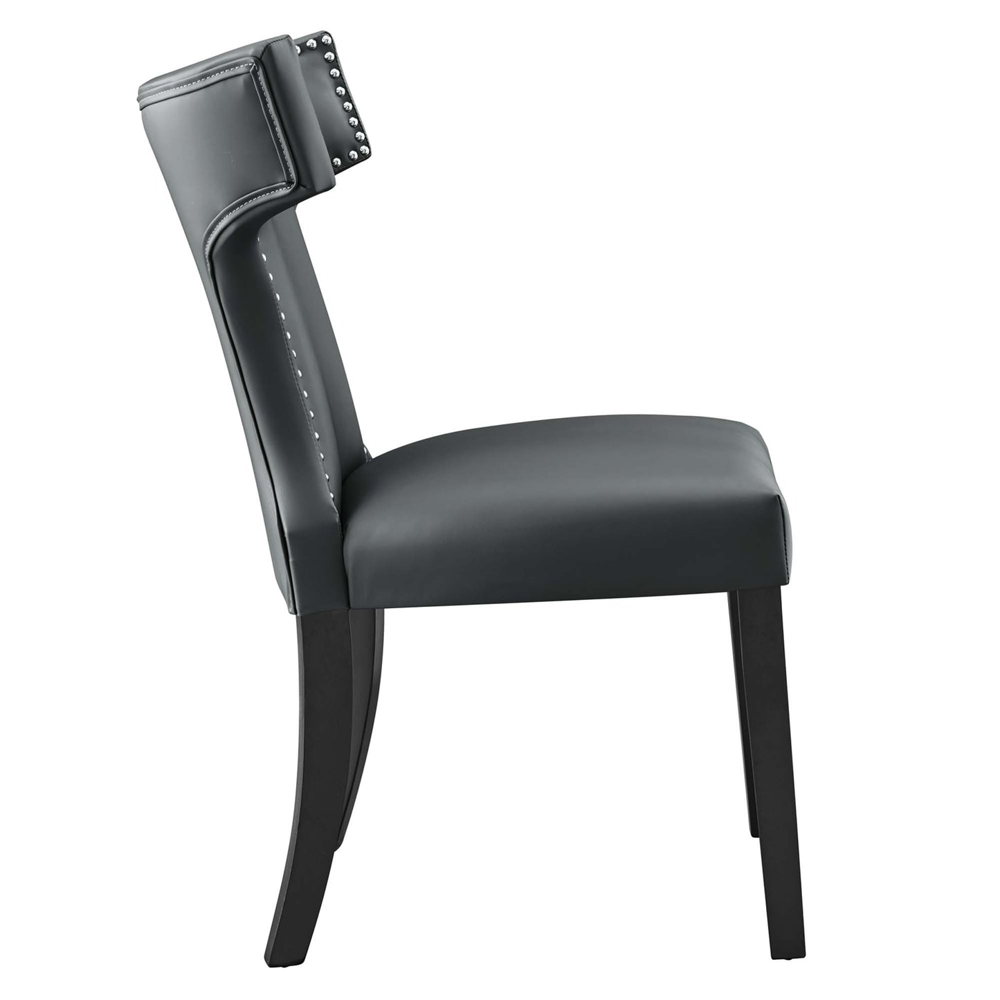 Gray vegan leather dining chair with padded backrest & nailhead trim & curved dark wood legs.