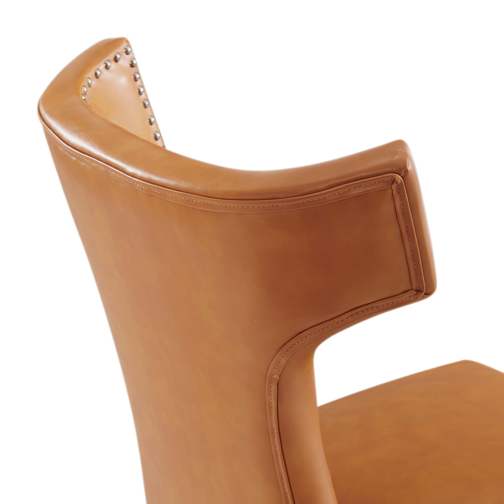 Tan vegan leather curved-back dining chair with studded nailhead trim.