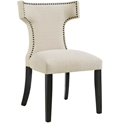 Beige upholstered dining chair with curved back, nailhead trim, and dark wood legs.