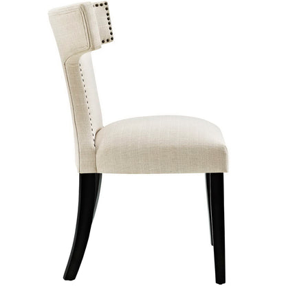 Brown upholstered dining chair with nailhead trim, curved back, cushioned seat, black curved legs.