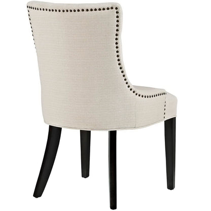 Beige fabric dining chair with curved back, dark wood legs, and nailhead trim along the edges.