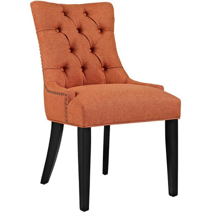 Orange tufted fabric dining chair with curved back, button tufting, nailhead trim and black tapered legs.
