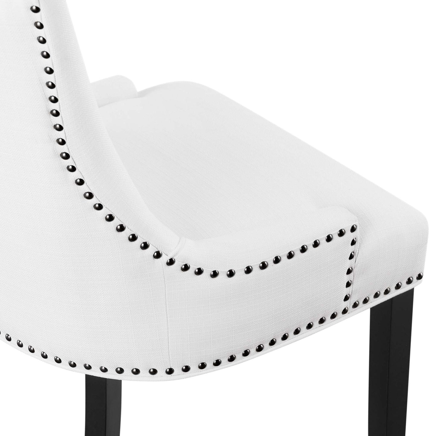 White upholstered chair with curved back, silver nailhead trim along edges & dark wooden legs.