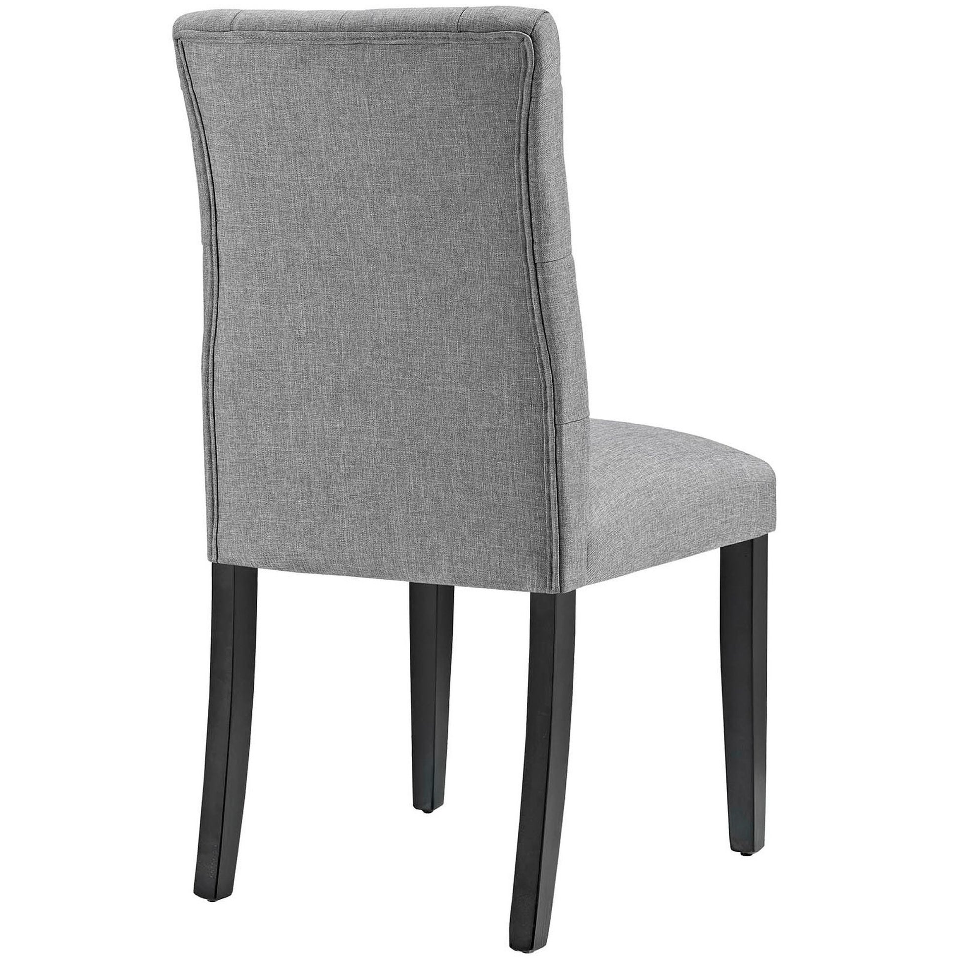 Light gray upholstered dining chair with curved back, piped edges, and dark wood legs.
