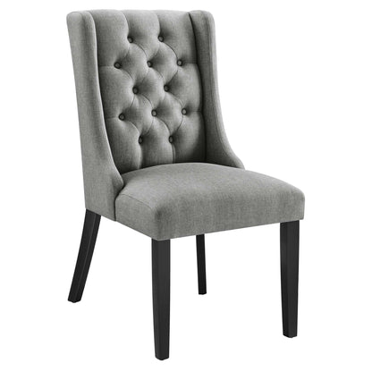 Grey tufted dining chair with tall back, buttoned backrest, cushioned seat and black tapered legs.