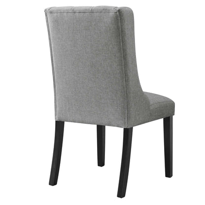 Grey upholstered dining chair with tall padded back, cushioned seat, and dark wooden legs.