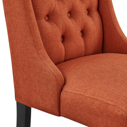 Orange textured fabric dining chair with button-tufted back, curved arms and dark legs.