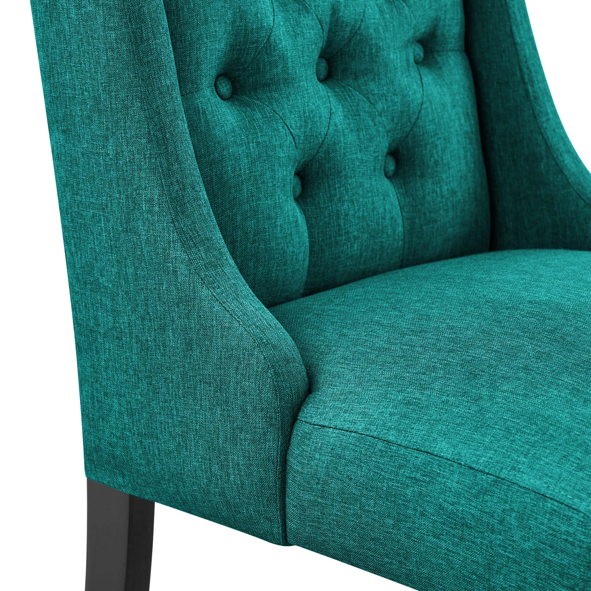 Teal fabric upholstered dining chair with tufted back and buttons, curved arms, and dark wood legs.