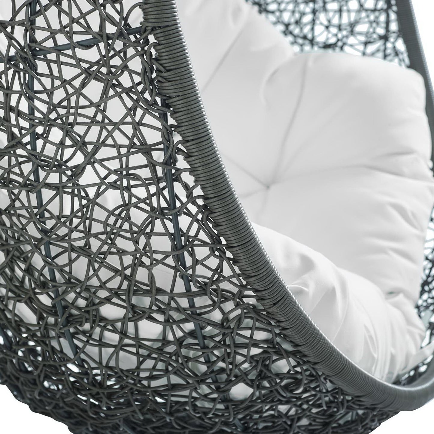 Dark gray woven rattan hanging chair with a plush white cushion, modern outdoor lounge style.