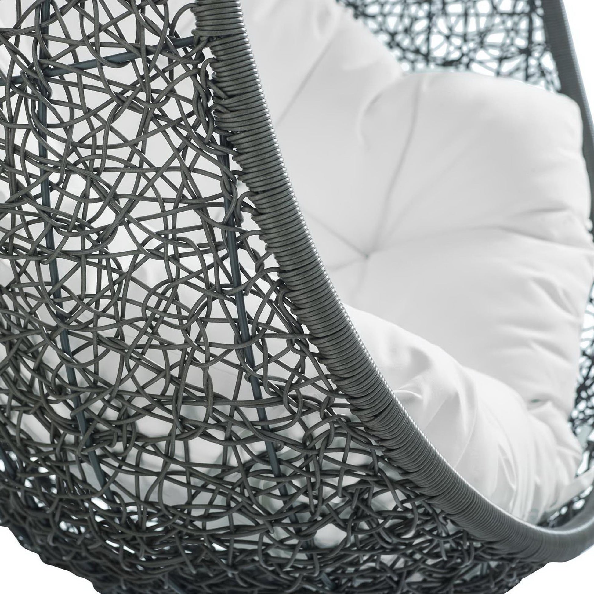 Dark gray woven rattan hanging chair with a plush white cushion, modern outdoor lounge style.