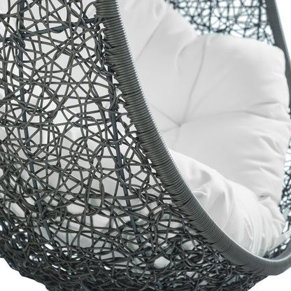 Dark gray woven rattan hanging chair with a plush white cushion, modern outdoor lounge style.