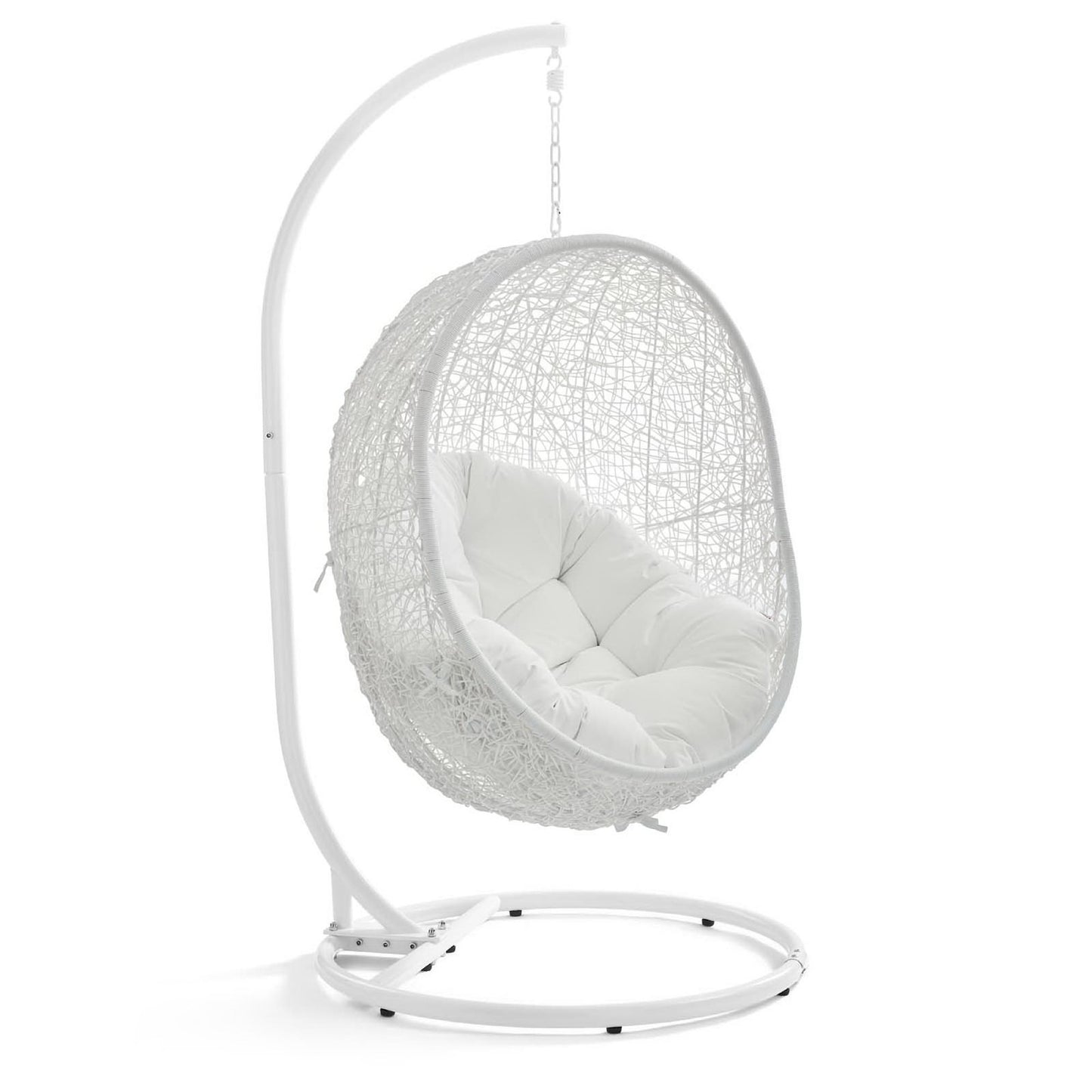 White hanging egg chair with woven rattan shell, plush white cushion & curved metal stand.