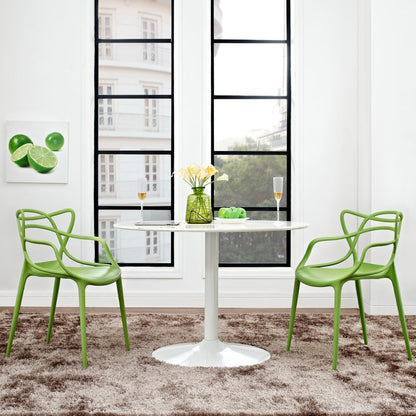Two green molded dining chairs in a bright modern dining nook.