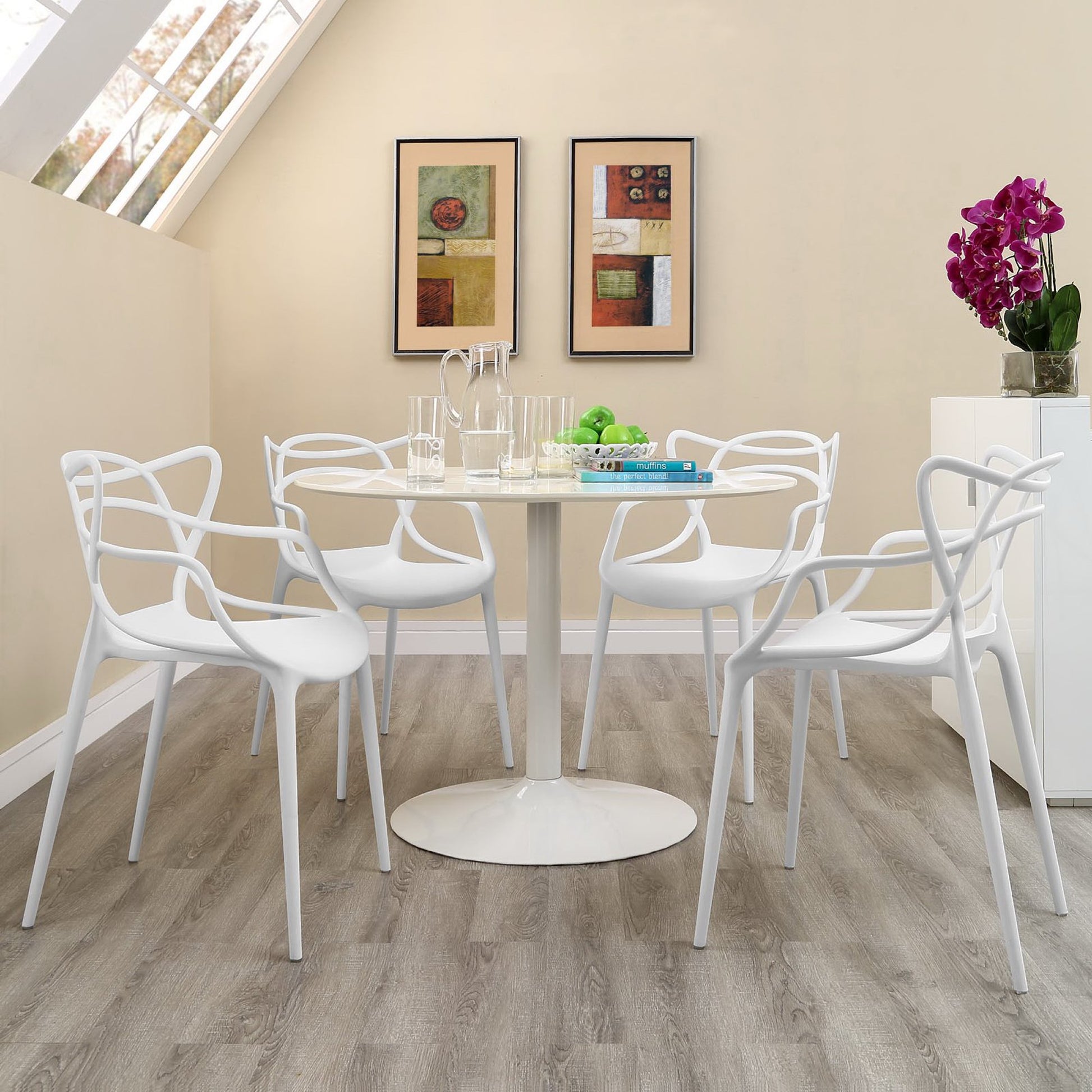White round pedestal dining table with six white molded chairs; modern minimalist set, glassware on table, purple orchid.