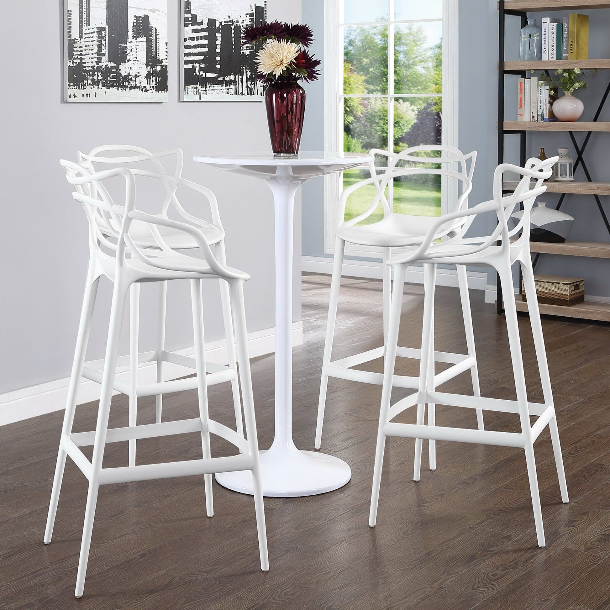Set of four white metal bar-height stools with sculpted backs in a bright contemporary dining nook.