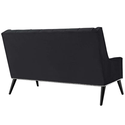 Black velvet loveseat with nailhead trim along base and tapered wood legs.