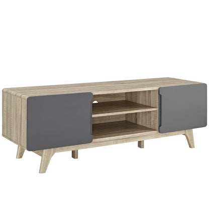 Natural oak finish TV console with two gray cabinet doors, open center shelves and angled mid-century legs.