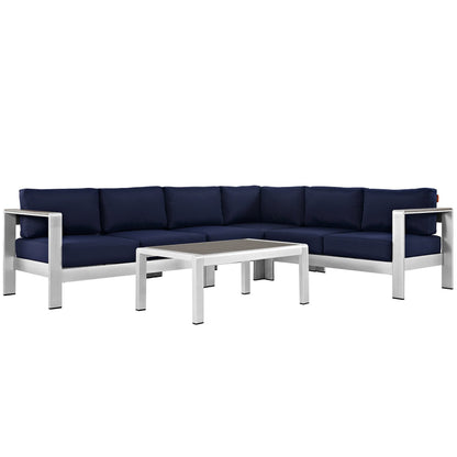 Outdoor aluminum-frame sectional sofa with navy cushions and a matching rectangular coffee table.