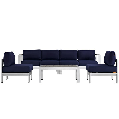 Outdoor modular sectional sofa set with navy cushions, silver aluminum frame, and a slatted rectangular coffee table.