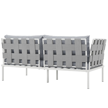 Outdoor aluminum loveseat with gray woven straps and plush gray cushions.