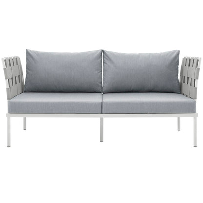 Outdoor two-seat lounge sofa with light gray cushions and white frame, slatted armrests.