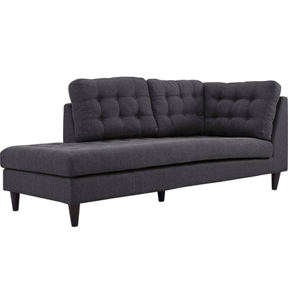 Dark gray fabric sofa with tufted back cushions and tapered wooden legs, chaise lounge style.