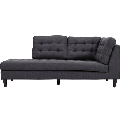Dark gray tufted fabric sectional sofa with low wooden legs and a left-side chaise.