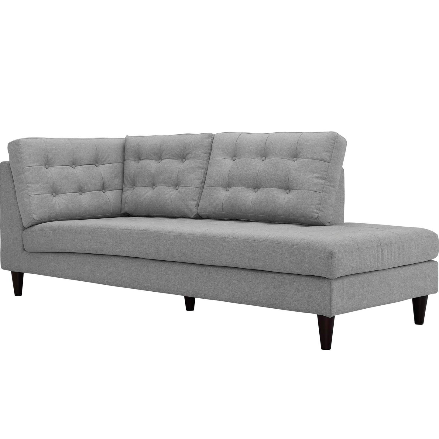 Gray fabric sectional sofa with tufted back cushions, low arms, chaise lounge on the right, tapered dark wood legs.