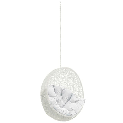White woven hanging egg chair on a chain with a soft gray cushion.