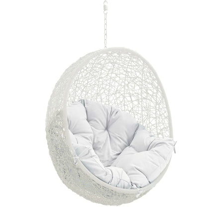 White woven hanging egg chair with plush light gray cushions, suspended by chain.
