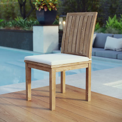 Natural wood outdoor dining chair with white cushion, slatted back, on a wooden pool deck.