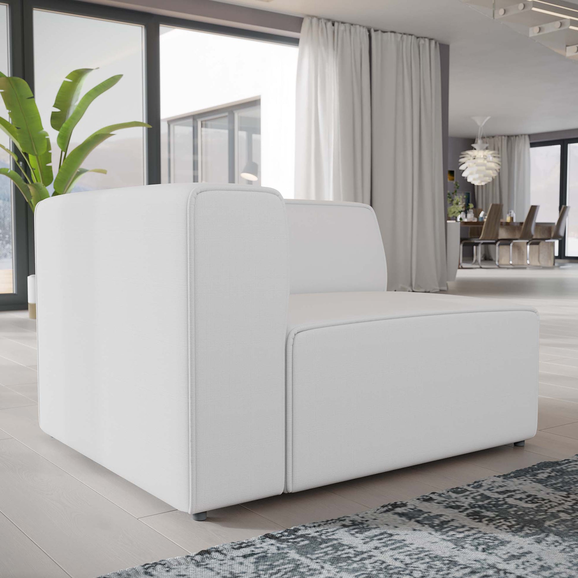 White modular sofa with square arms and low cushions in a modern open-plan living space.